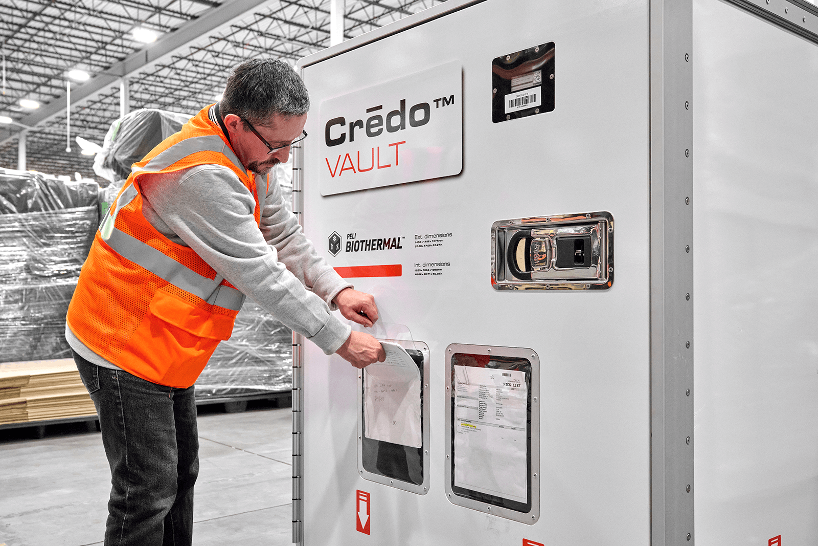 Man in orange vest loading Crēdo Vault