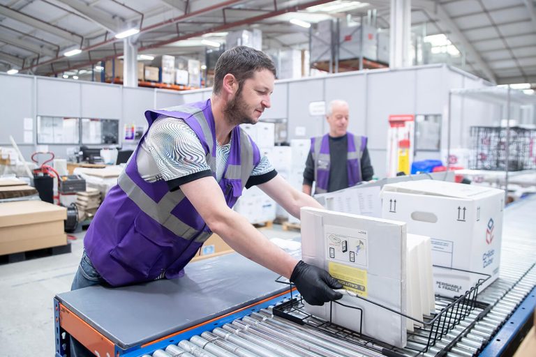Man in purple vest inspecting components
